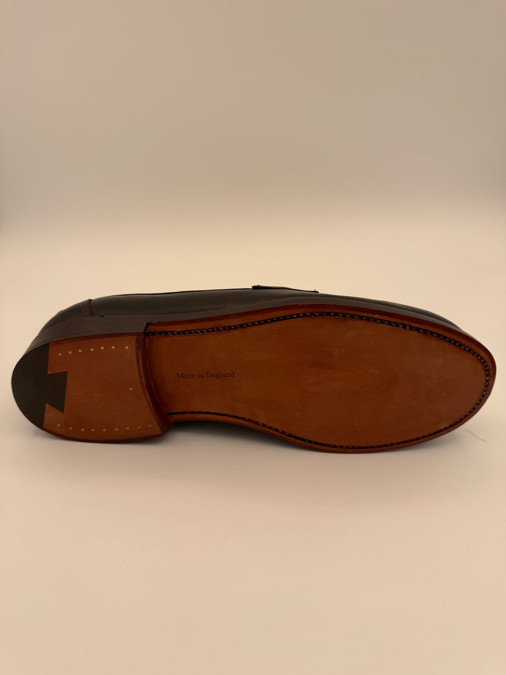 Brown leather loafer shoe on a beige background