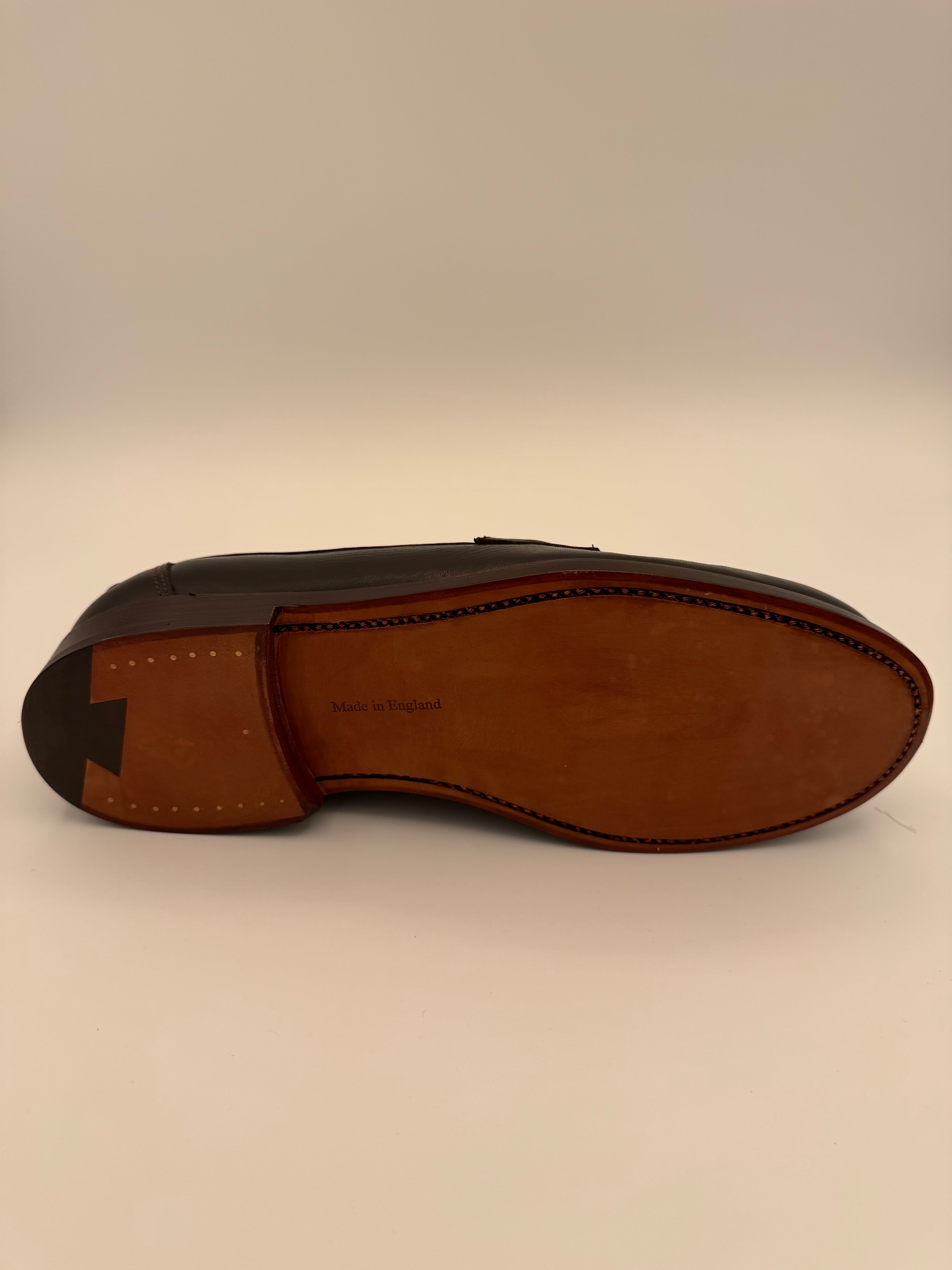 Brown leather loafer shoe on a beige background