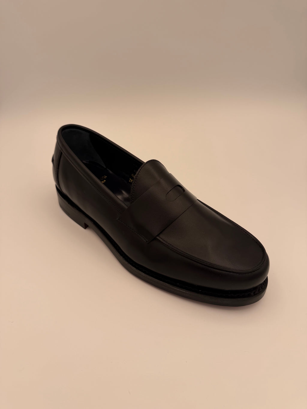Black shoe on a beige background