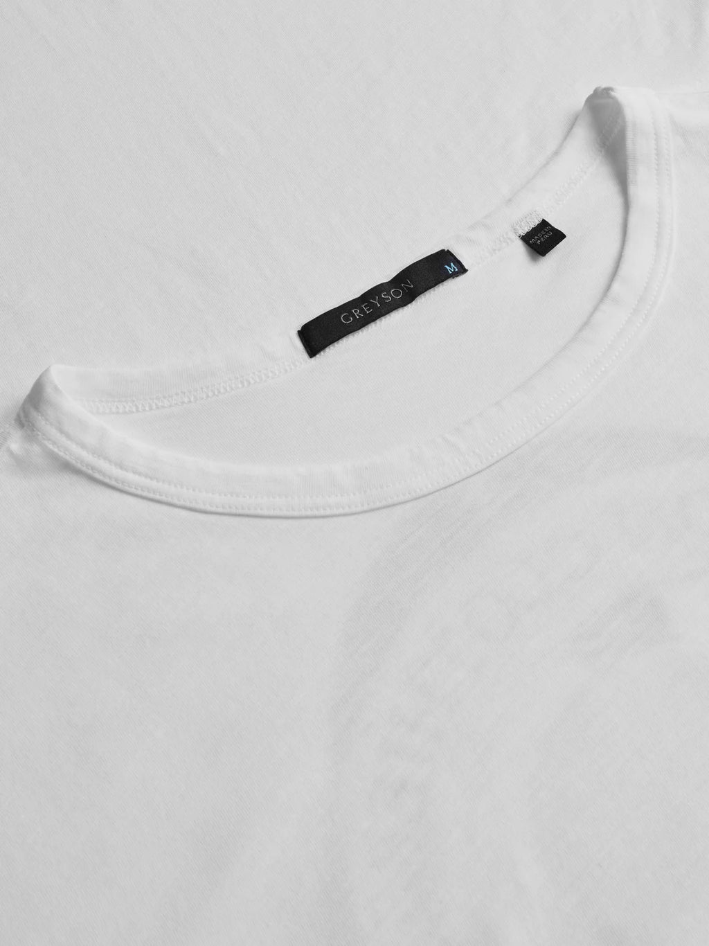 Close-up of a white t-shirt with a brand label on the collar.