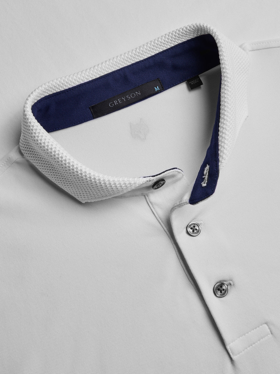 Close-up of a white shirt with a blue collar and 'GREYSON' label on a light gray background