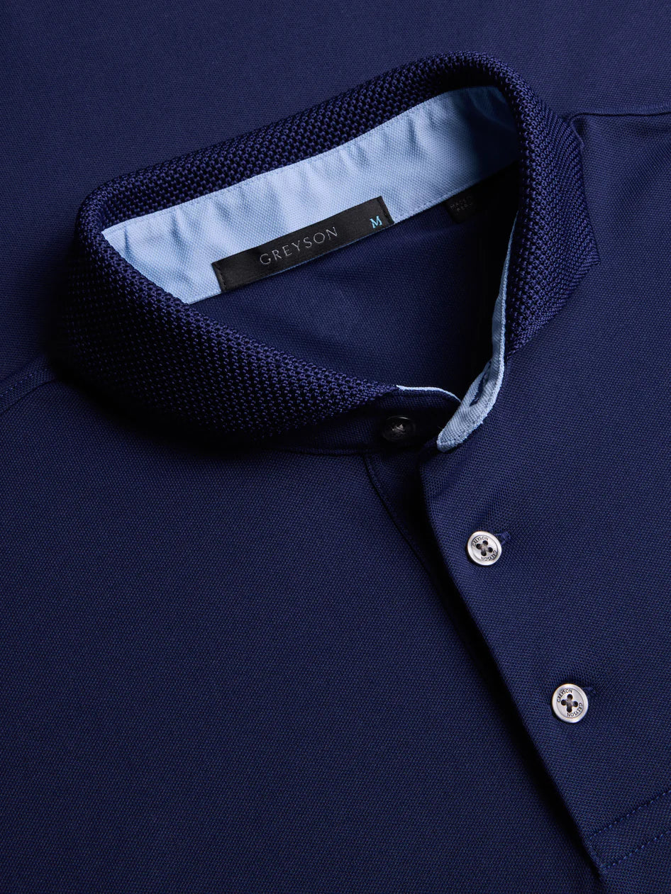 Close-up of a navy blue shirt with a brand label on the collar.