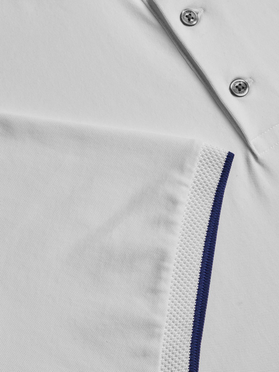 Close-up of a white shirt with blue zipper detail on a light gray background