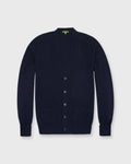 Navy blue cardigan with button details on a light gray background